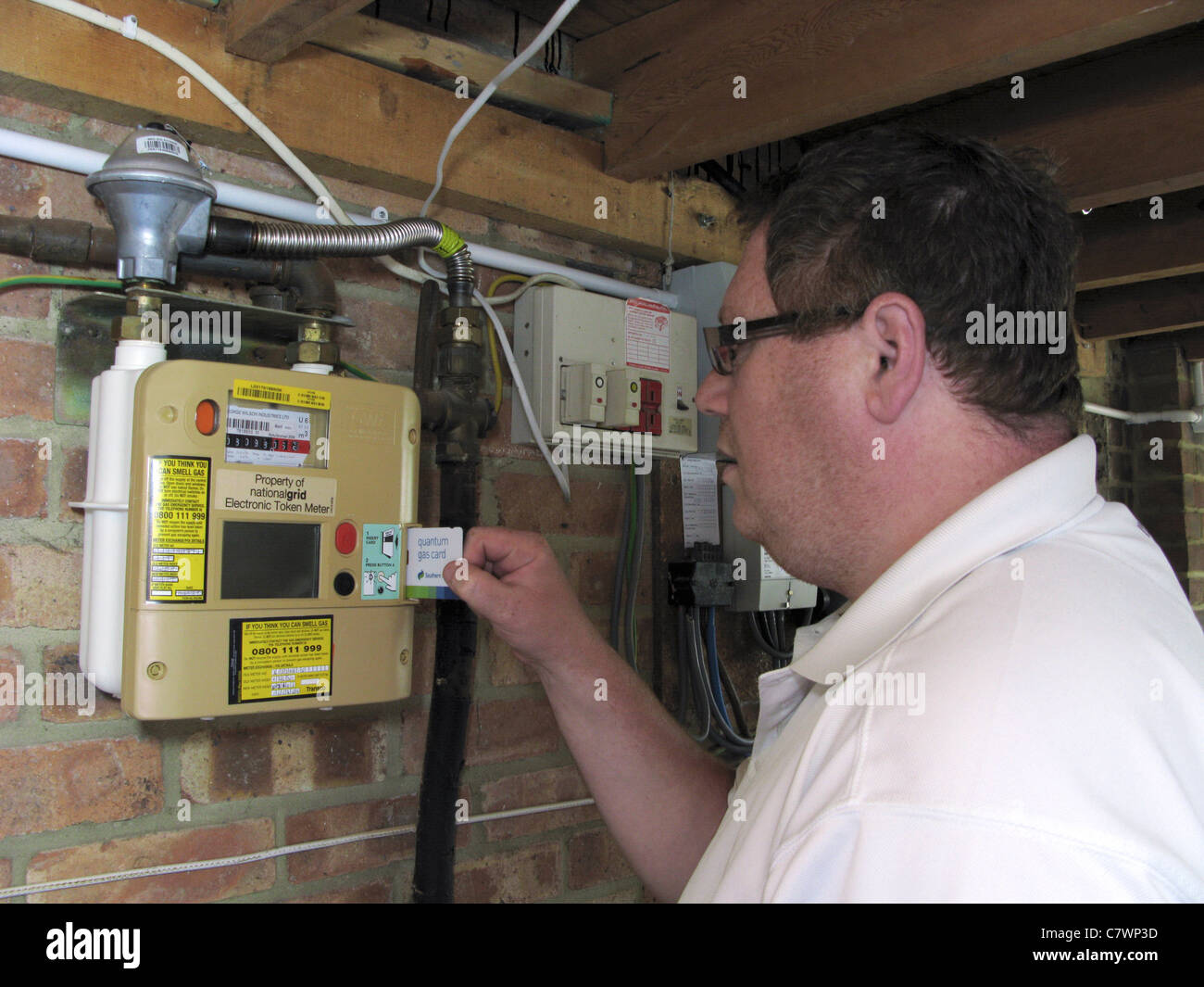 Uomo che utilizza un quantum key prepagamento misuratore di gas, pagando per gas come si usa Foto Stock