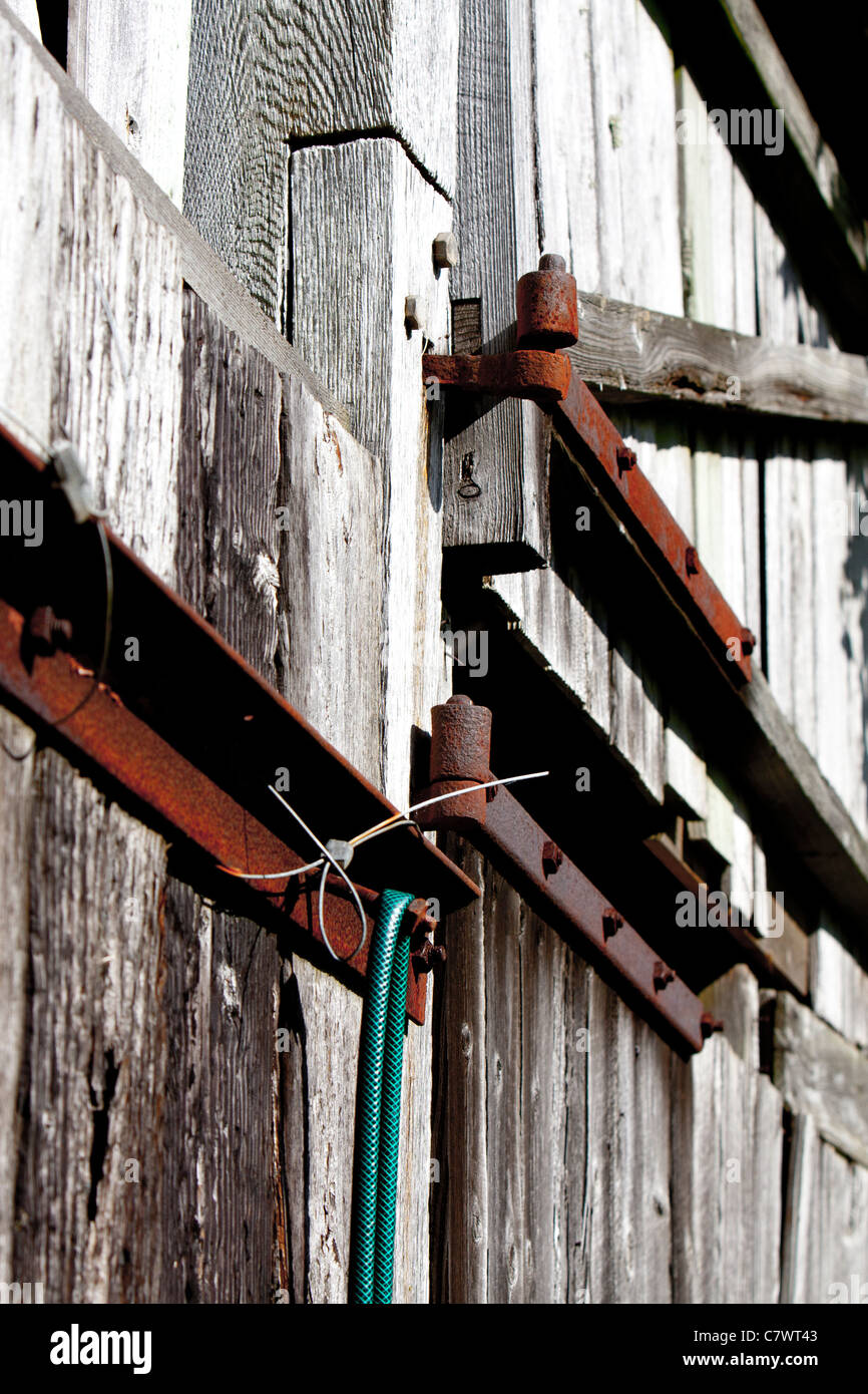 Cerniere arrugginito che tiene insieme una vecchia fattoria Foto Stock