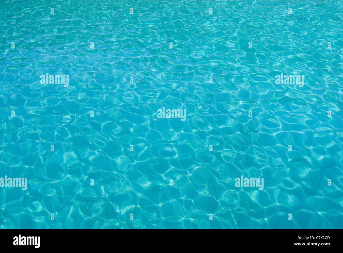 Mare azzurro e limpido in una giornata di sole con riflessi di sole la creazione di una massa di intriganti forme e modelli. Invitante prospettiva. Foto Stock