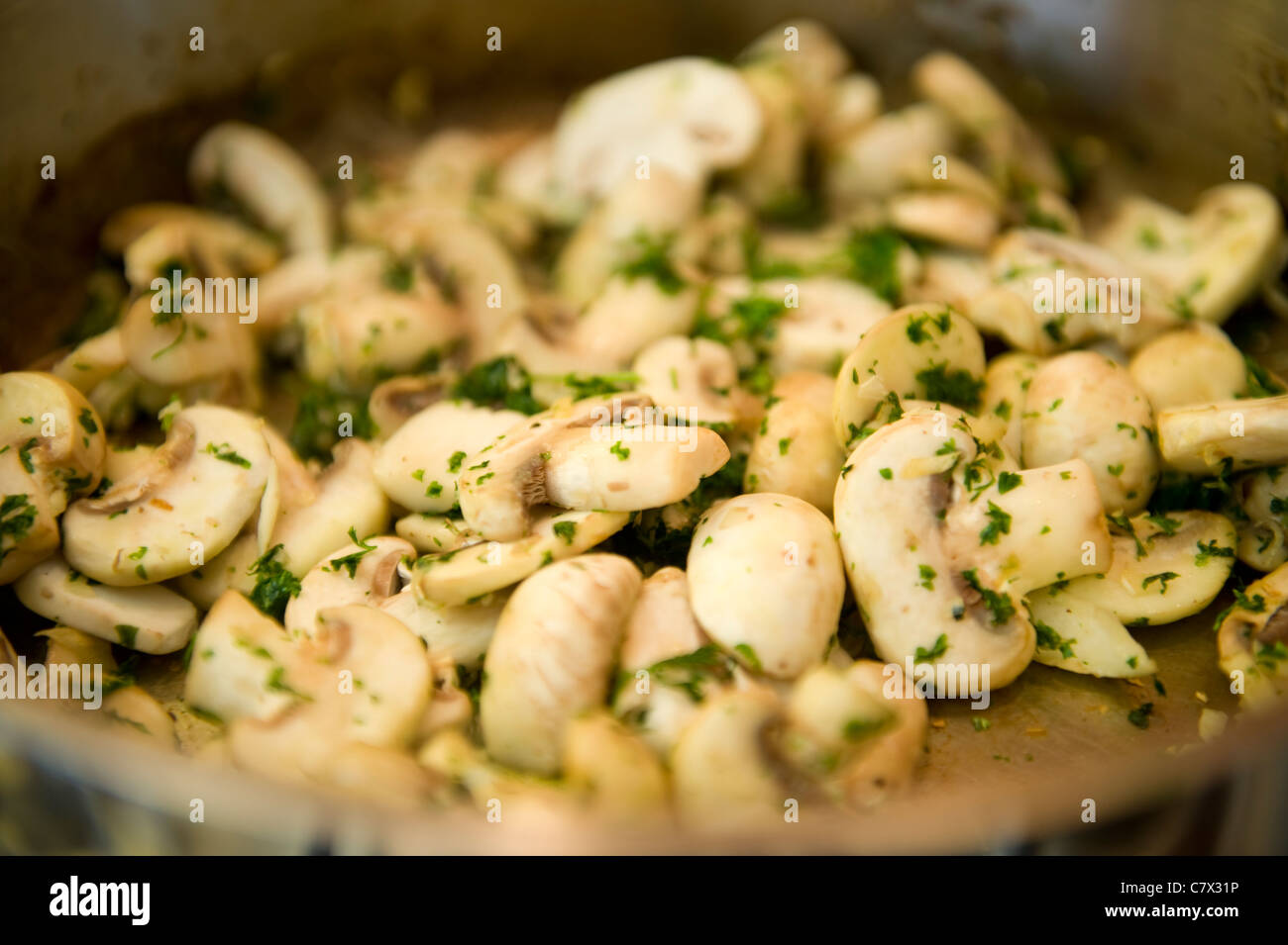 I funghi in padella con prezzemolo e aglio in padella Foto Stock