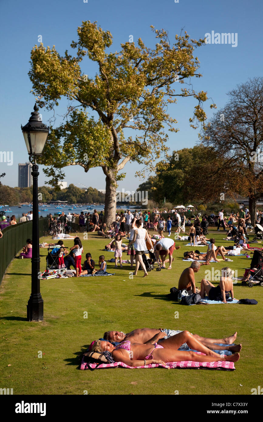 Estate ondata di calore colpisce Londra ed il Regno Unito. La gente seduta fuori nel sole in Hyde Park. Foto Stock