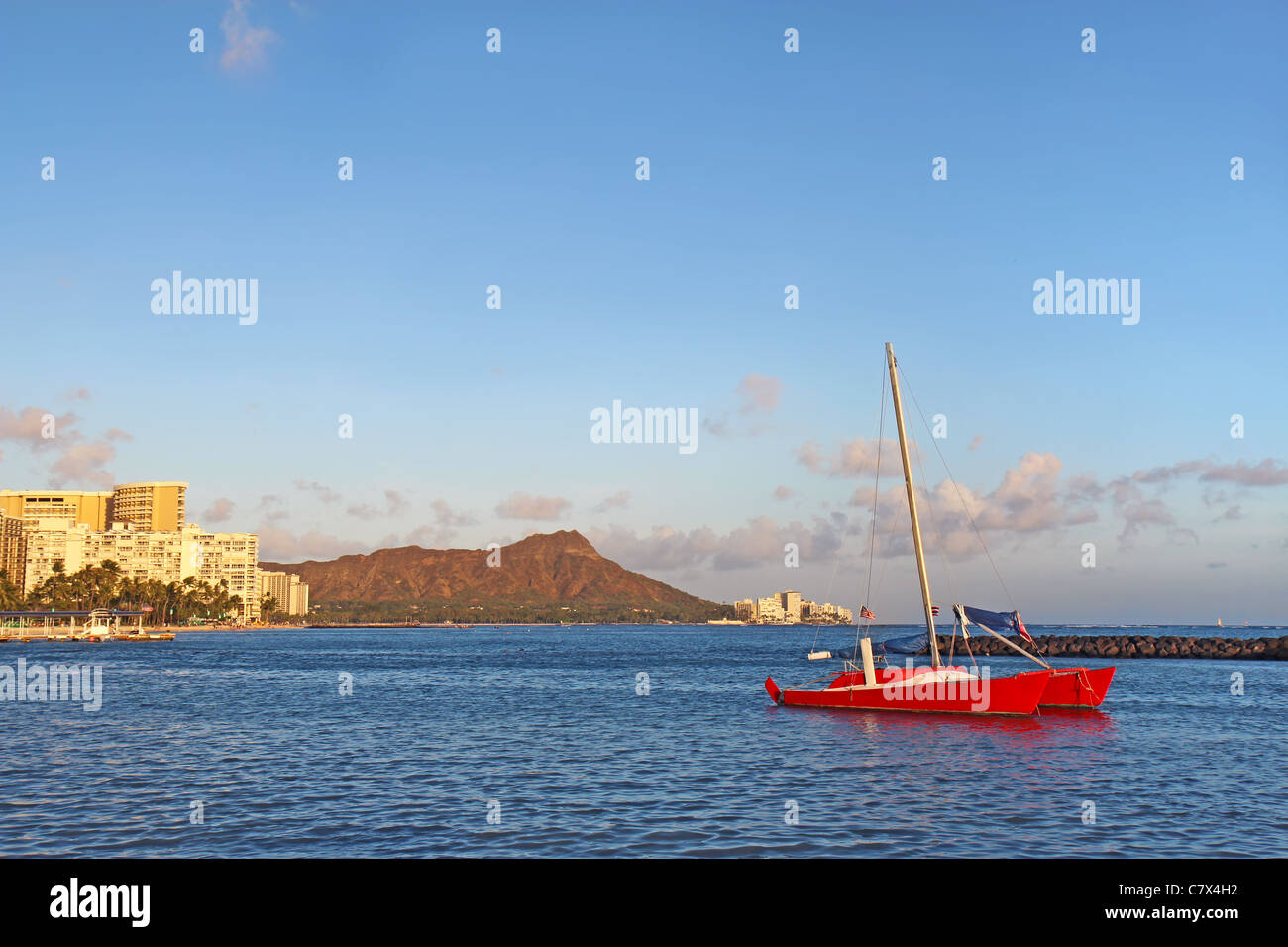 Catamarano e molti alberghi lungo la spiaggia di Waikiki a Honolulu, Hawaii, con cono vulcanico del Diamond Head in background Foto Stock