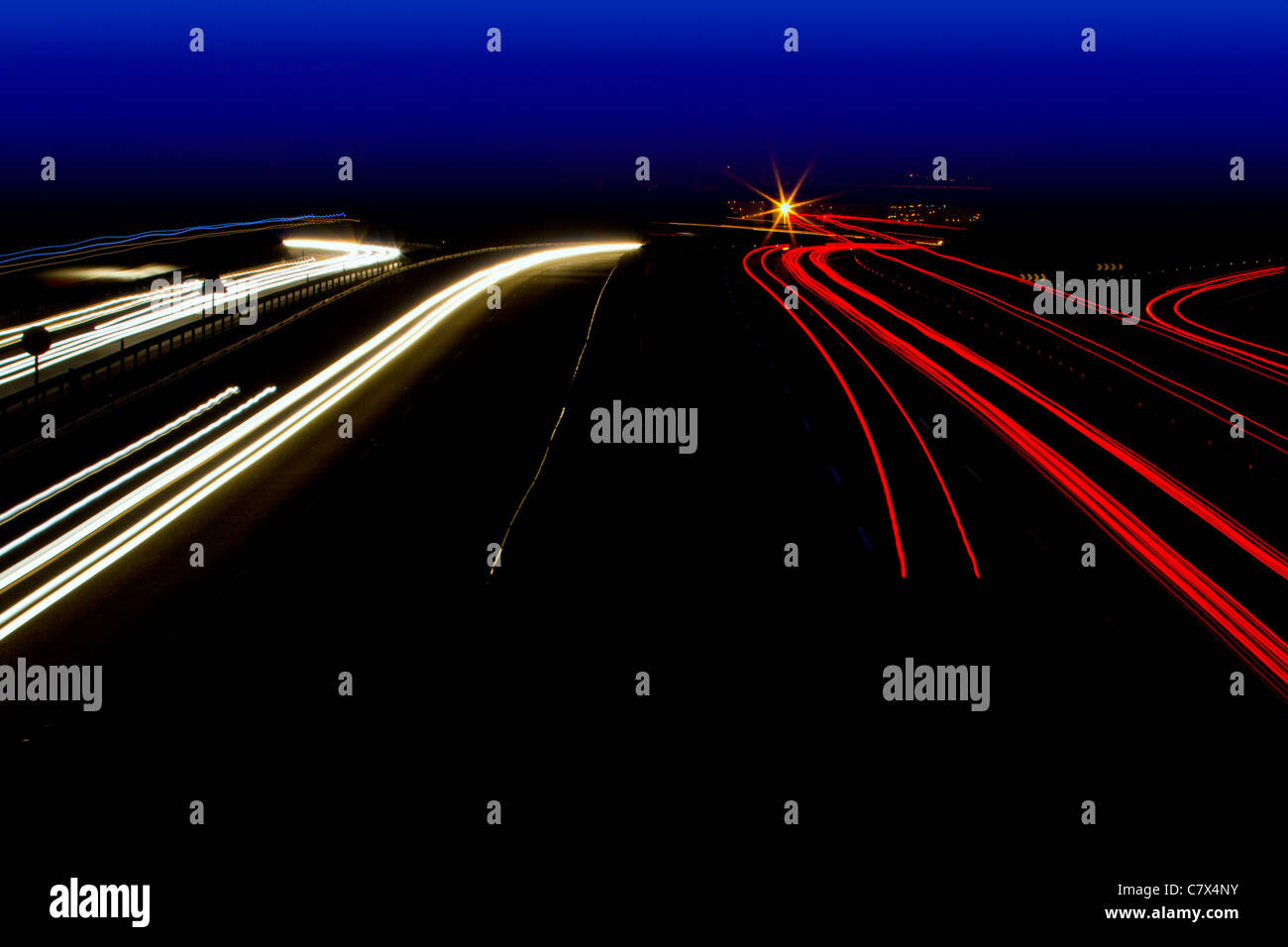 Auto sentieri di luce in bianco e rosso su strada di notte la curva Foto Stock
