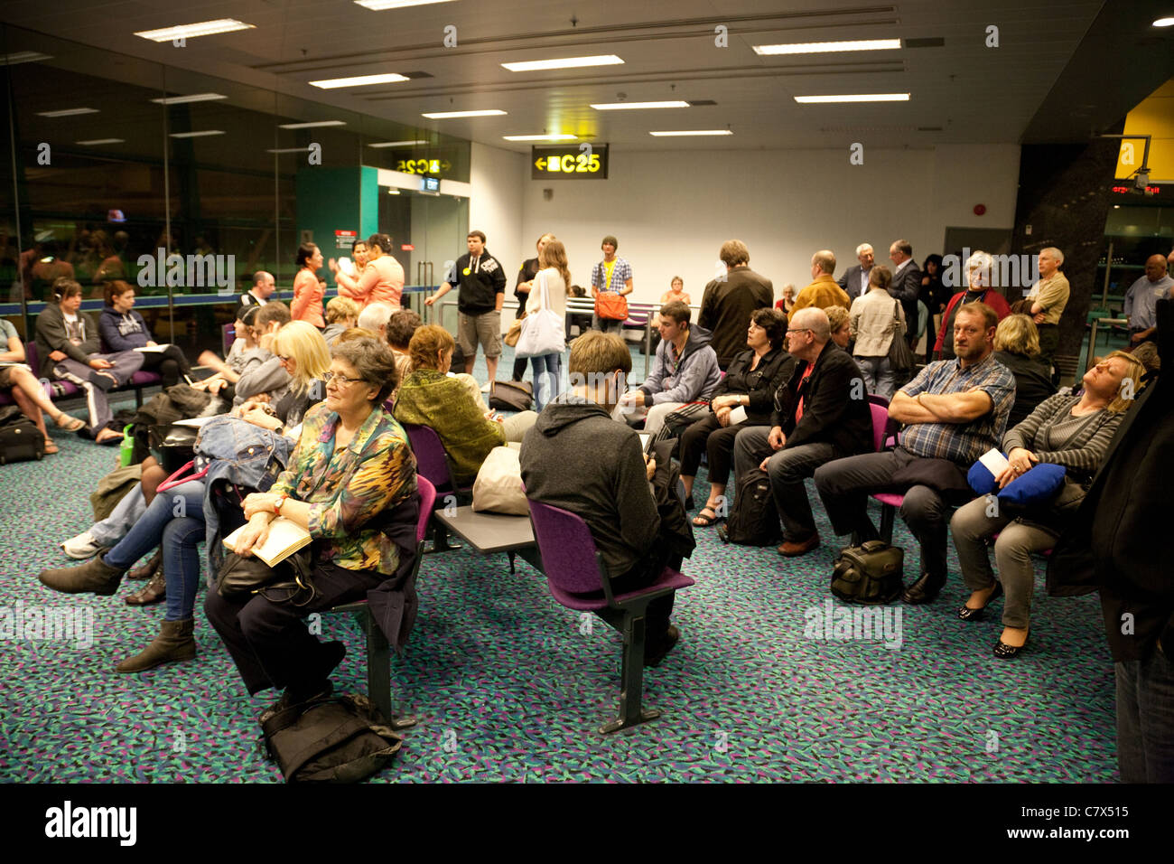 La folla dei passeggeri del trasporto aereo in attesa presso il cancello per il loro volo, la partenza lounge, l'Aeroporto Changi di Singapore Asia Foto Stock
