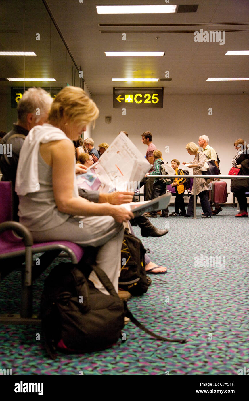 La gente in coda a bordo di un piano in corrispondenza della gate, l'Aeroporto Changi di Singapore Foto Stock