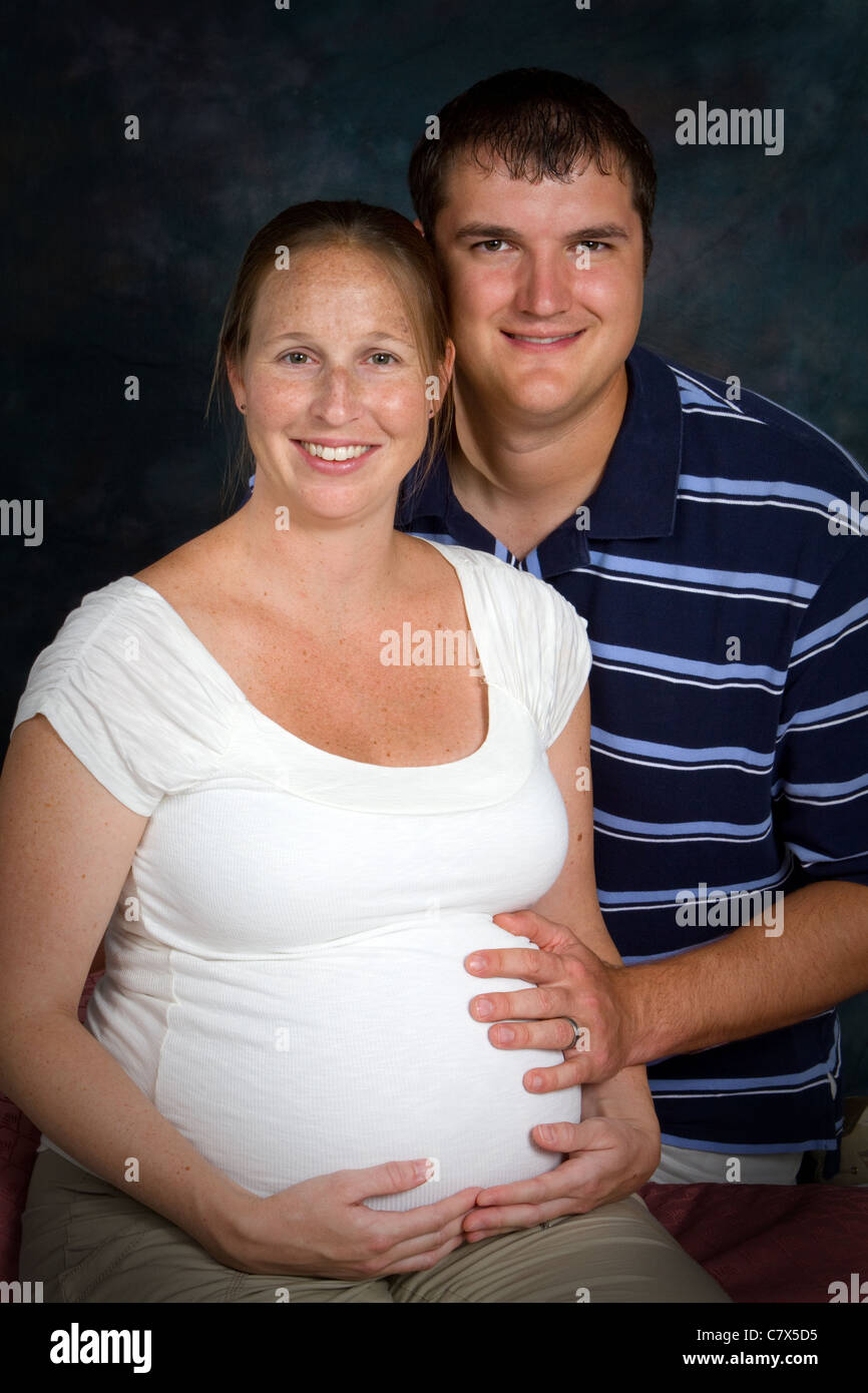 Gestanti matura in una formale fotografia portrait session con la donna che presenta la maschera di gravidanza. Foto Stock