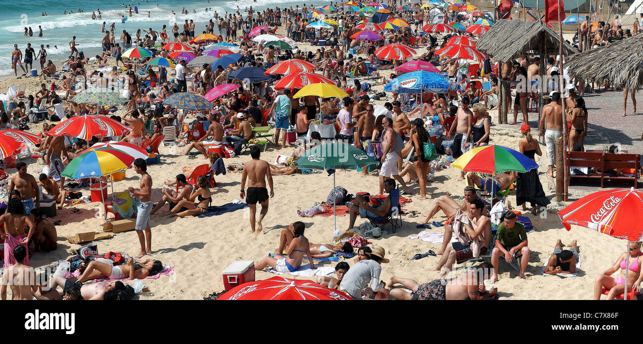 La vacanza estiva. holiday maker su una spiaggia affollata. Fotografato a Nitsanim Beach, Israele Foto Stock
