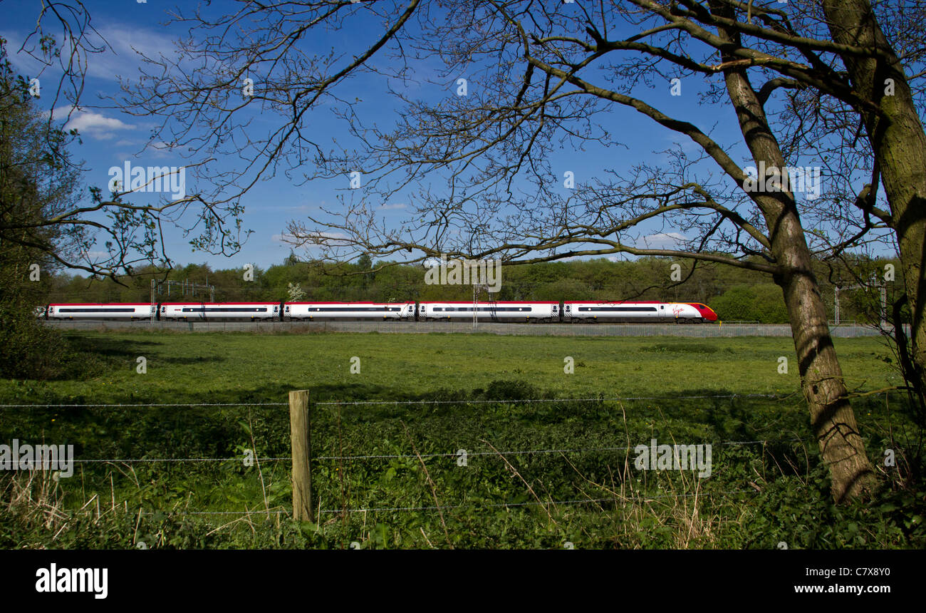 Una vergine classe treno 390 Pendolino passando Slindon, Mill Meece, Staffordshire. Il 3 maggio 2011 Foto Stock