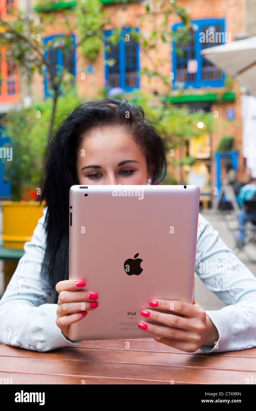 Adolescente utilizzando Apple iPad 2 tablet pc all'aperto, London, England, Regno Unito Foto Stock
