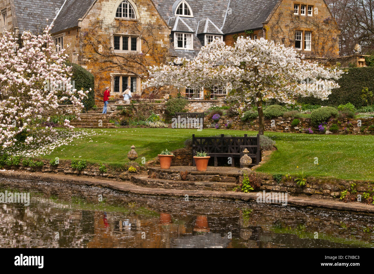 Gli ospiti godono i tranquilli giardini di Coton Manor in primavera, Coton, Northamptonshire, Inghilterra per solo uso editoriale Foto Stock