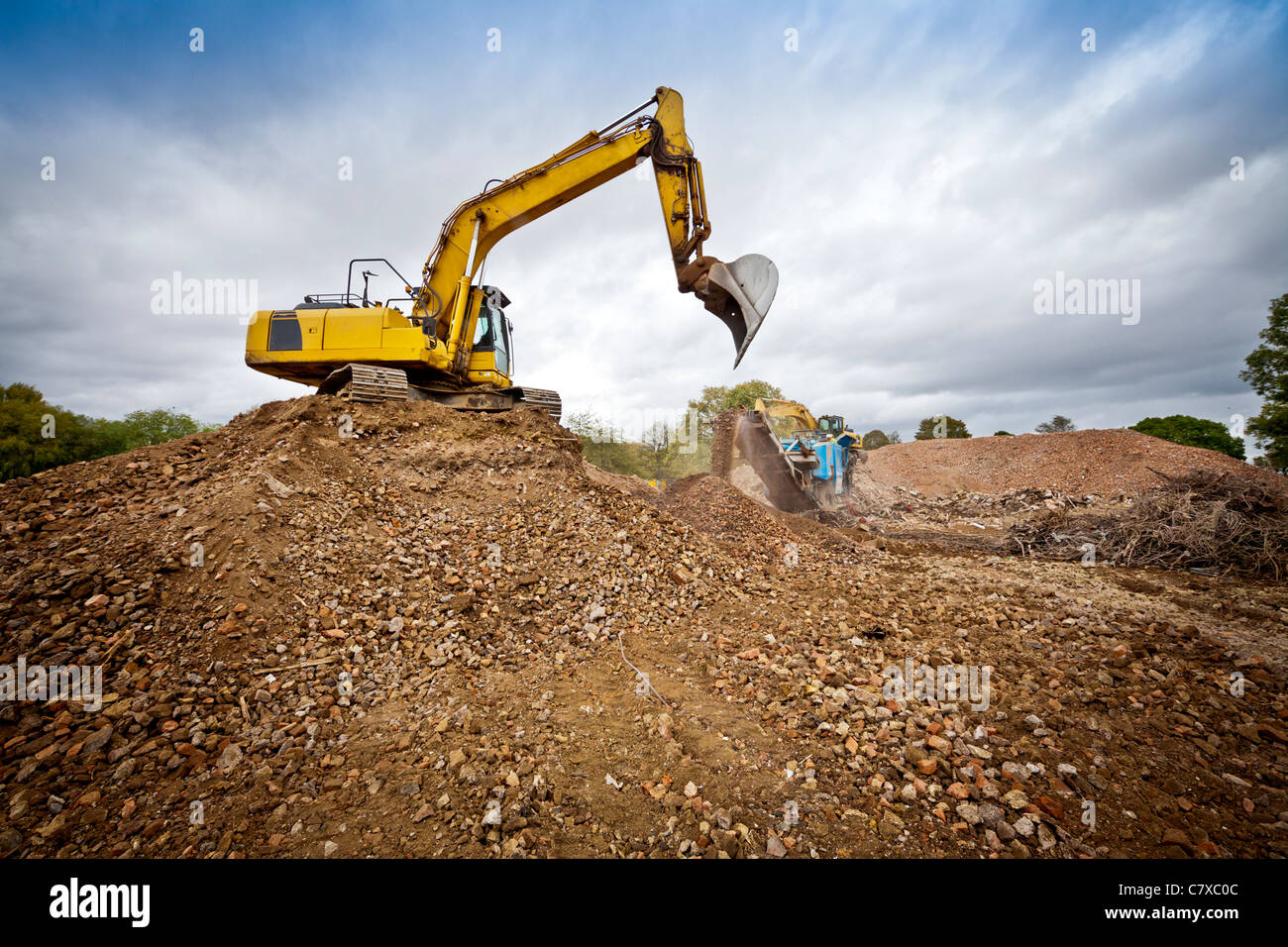 Demolizione e opere di massa sul sito di costruzione con costruzione di veicoli in funzionamento Foto Stock
