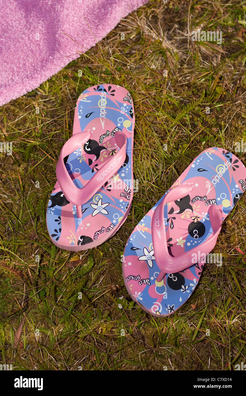 Un paio di pantofole per bambini giacente sul grassq Foto Stock