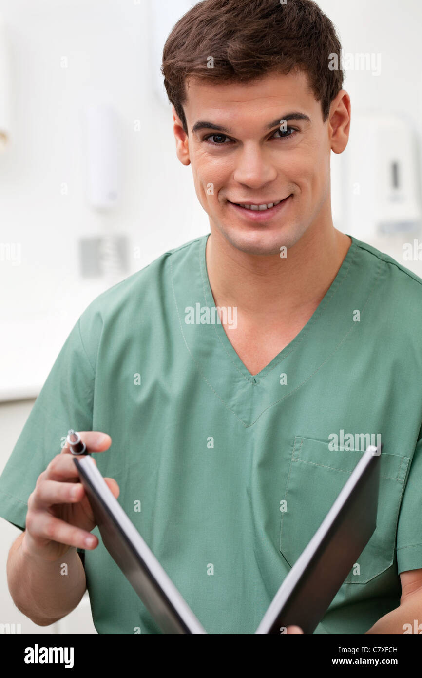 Ritratto di medico in possesso di un libro e sorridente Foto Stock