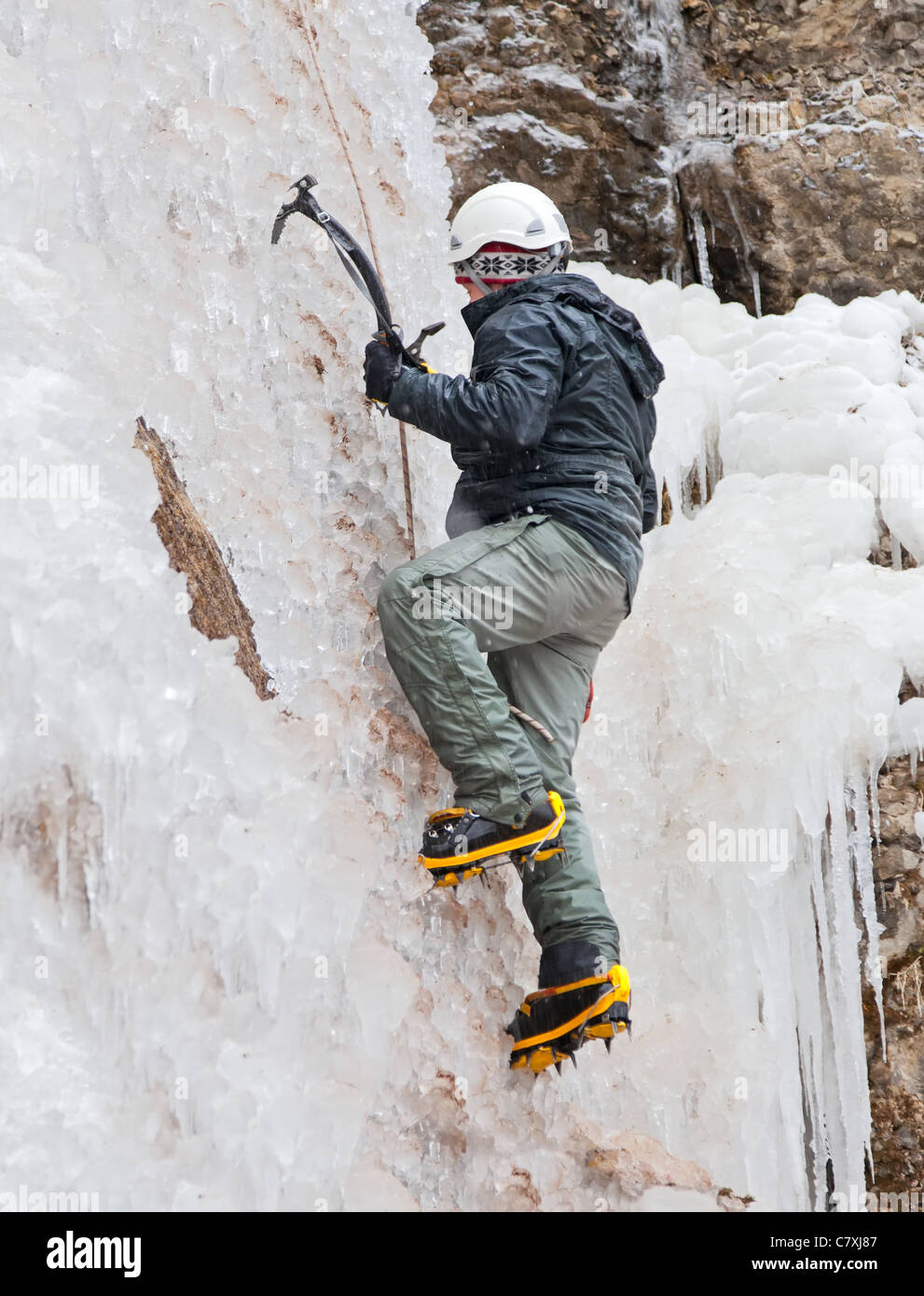 Uomo con piccozze e ramponi salendo sul ghiacciaio Foto Stock