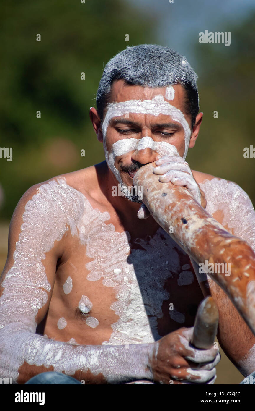 Aborigeno australiano uomo che indossa la faccia / body paint e suonare il didgeridoo (maschio Koori didgeriodoo player) Foto Stock