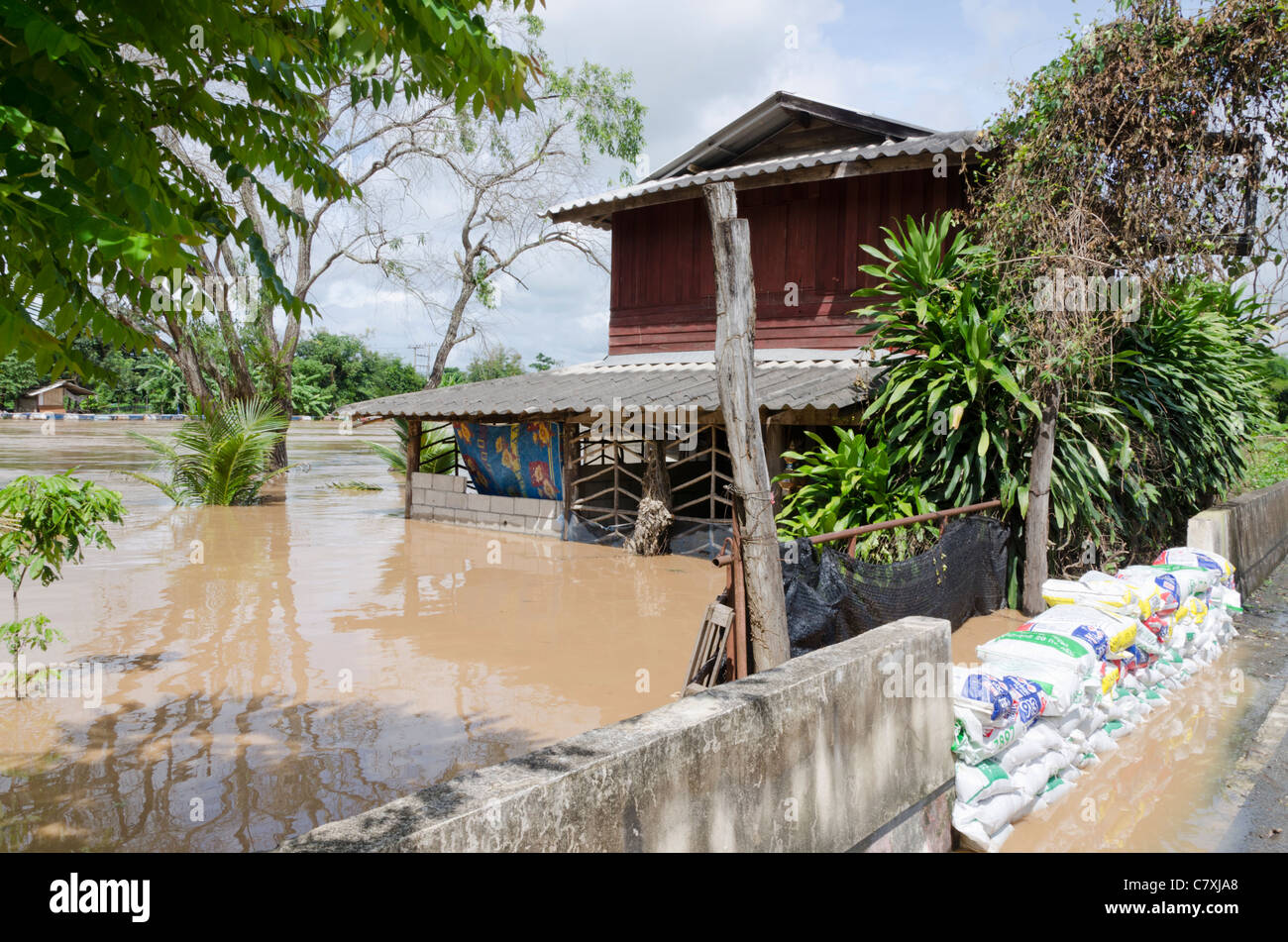 Inondato due piani di casa con la barriera di cemento e sabbia bloccando acque alluvionali al fiume Ping a sud di Chiang Mai Thailandia Foto Stock