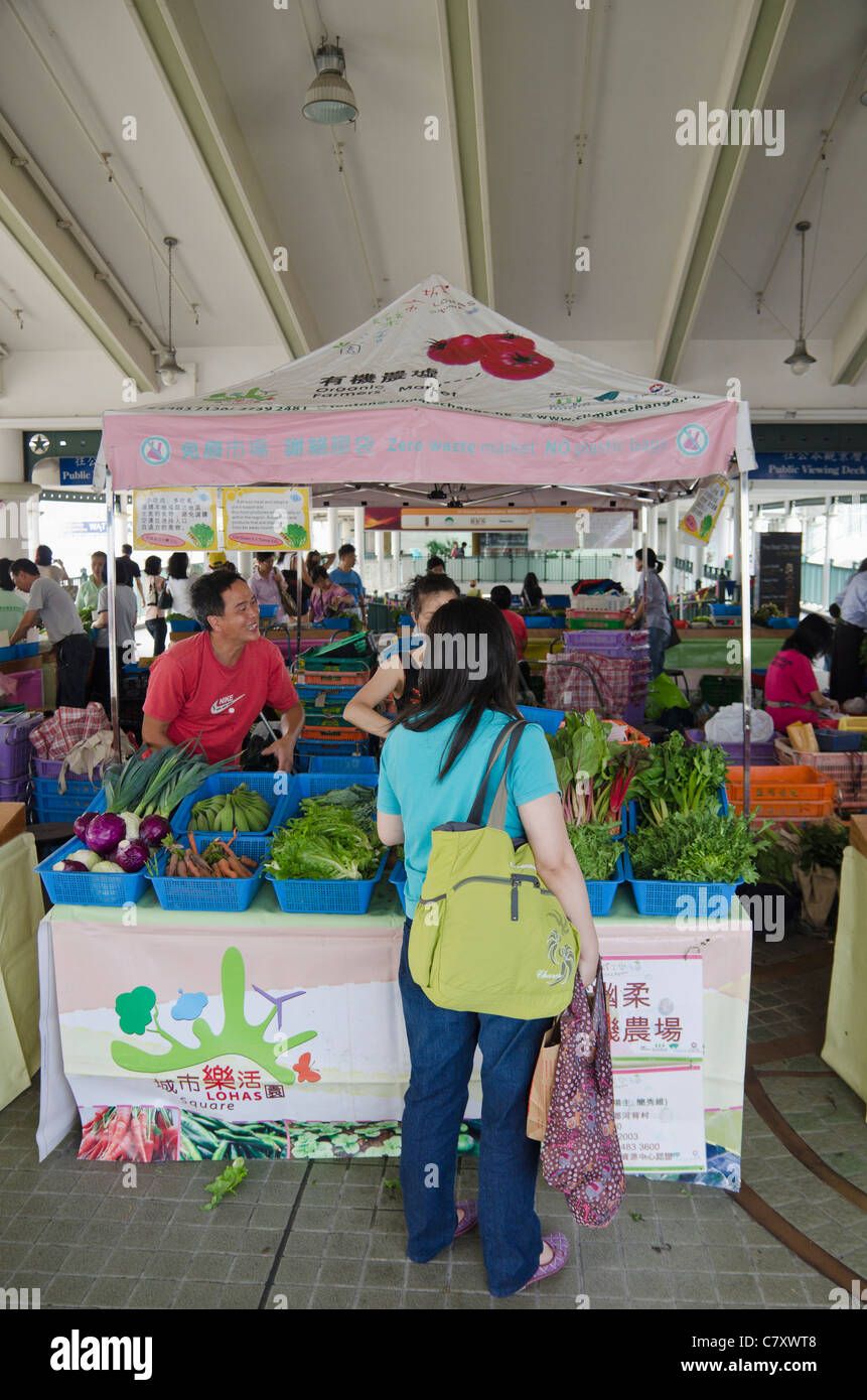 Donna shopping presso una piazza LOHAS organic farmers market lungo il Molo Star Ferry, centrale, Hong Kong, Cina Foto Stock