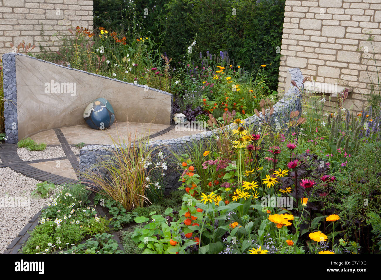 Piccolo giardino urbano cortile Cottage con cerchio circolare di pietra pavimentazione pavimentata e ghiaia patio misto confine estivo confine siepe confine Regno Unito Foto Stock