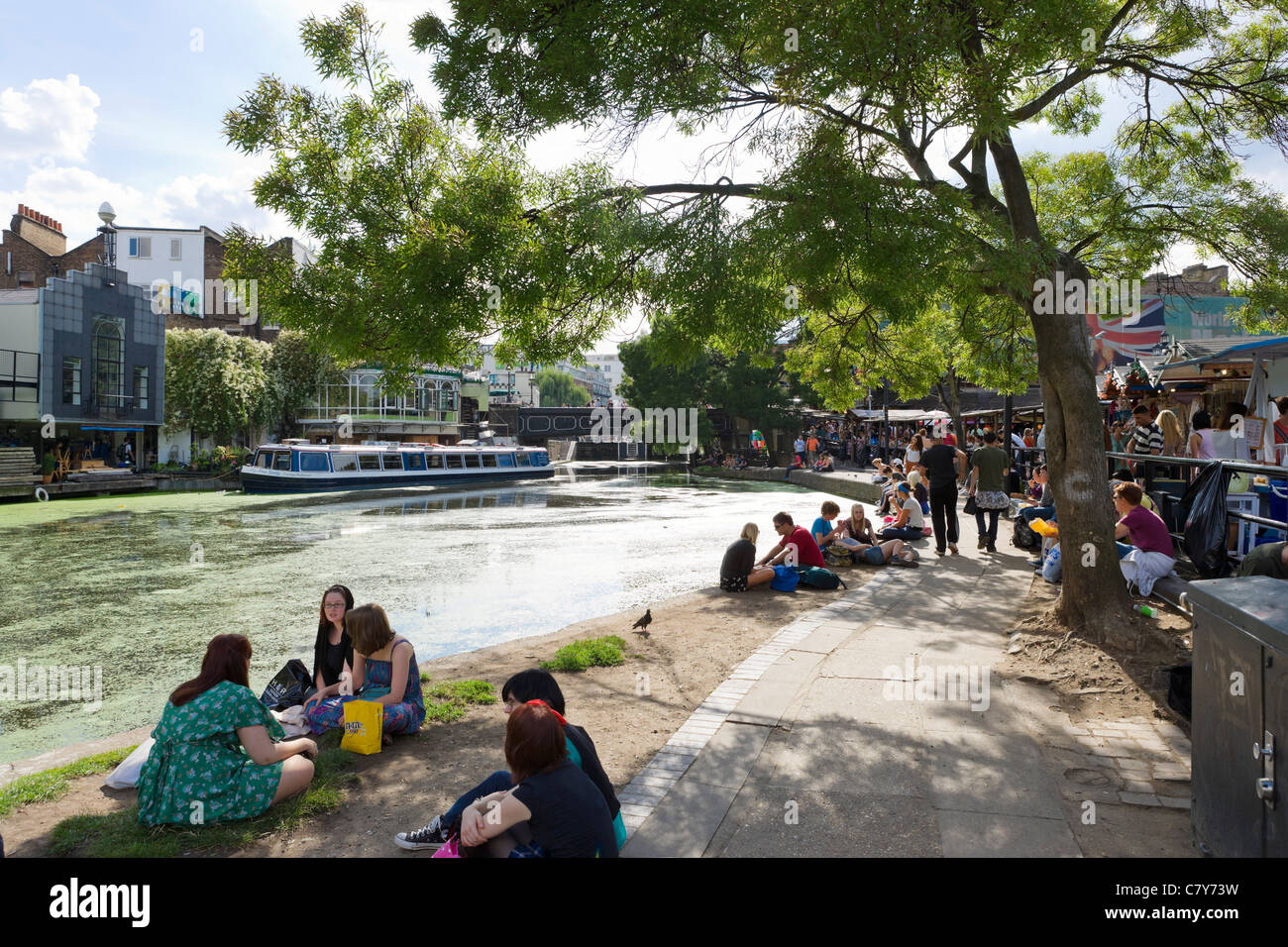 I giovani seduti lungo le rive del Regent's Canal a Camden Lock, a nord di Londra, England, Regno Unito Foto Stock