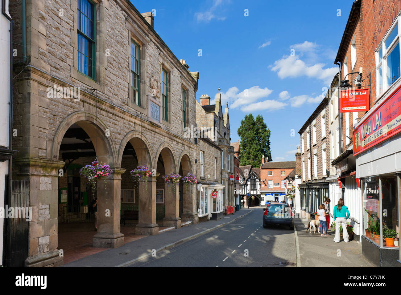 I negozi di High Street con il Corn Exchange a sinistra, Much Wenlock, Shropshire, Inghilterra, Regno Unito Foto Stock