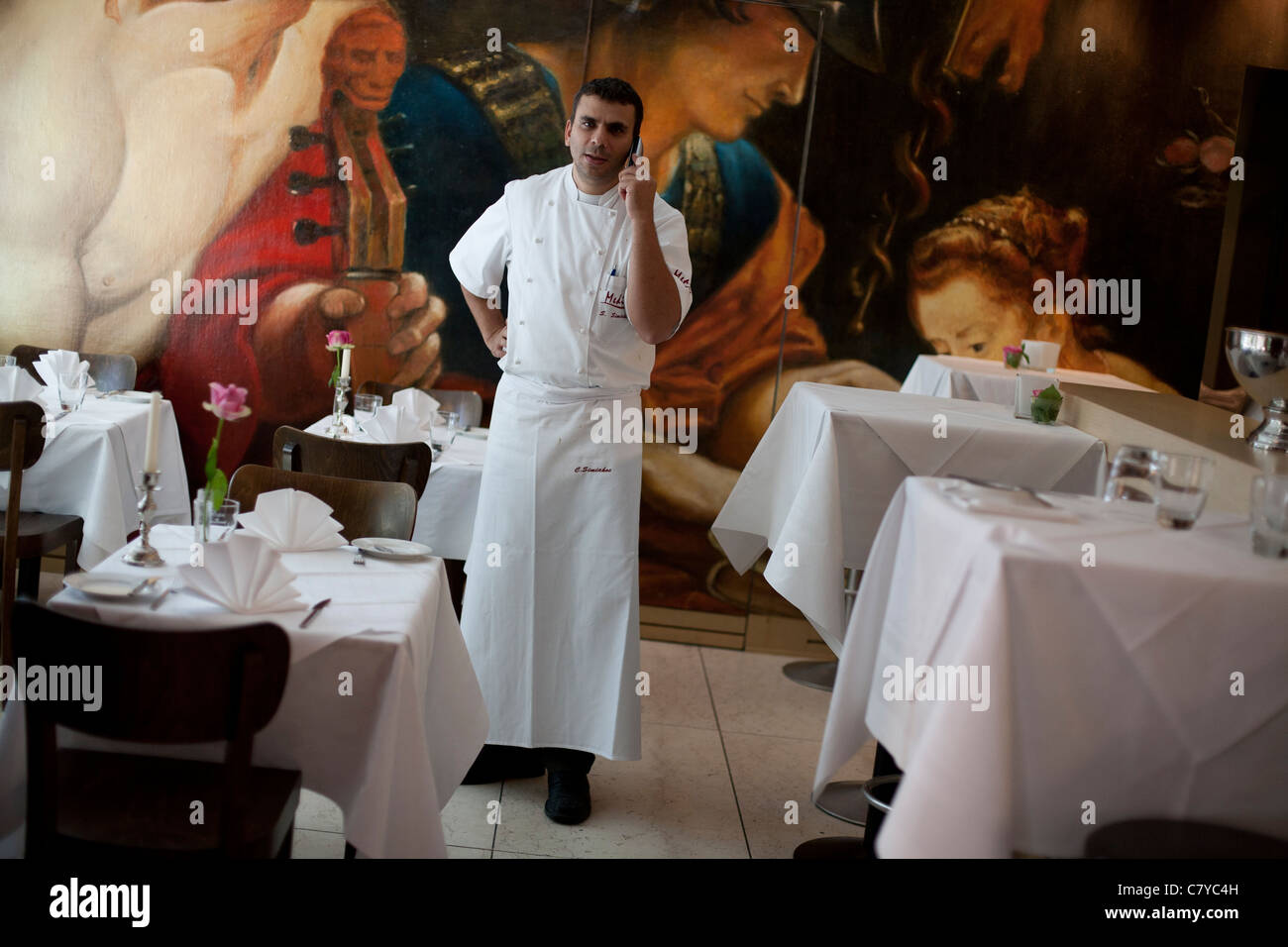 Un Cuoco che parla al telefono in un ristorante italiano a Francoforte in Germania. Foto Stock