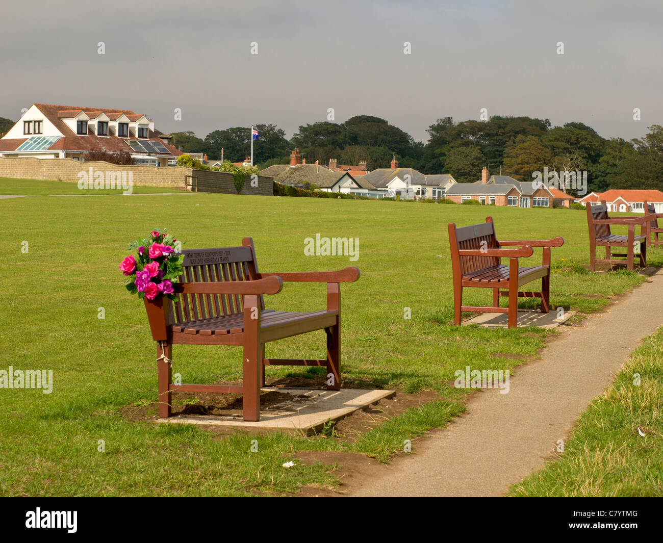 Memorial fiori su una panchina nel parco da una scogliera percorso superiore, Bridlington, East Yorkshire, Inghilterra Foto Stock