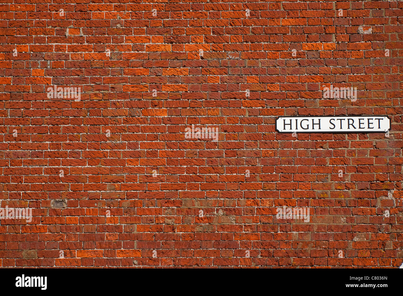 Comunicazioni, segnaletica, High Street sign in rosso un muro di mattoni. Foto Stock