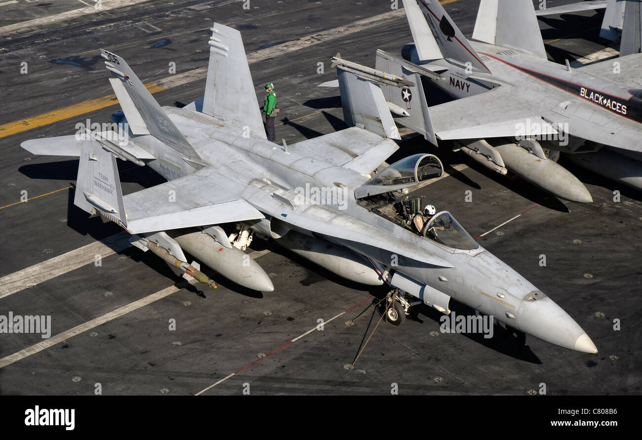 Un US Navy F/A-18C Hornet parcheggiata sul ponte di volo della portaerei USS Nimitz. Foto Stock