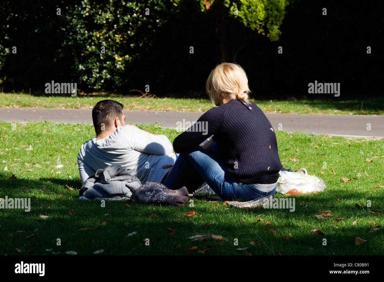 Coppia giovane relax nel parco sul giorno di autunno caldo Foto Stock