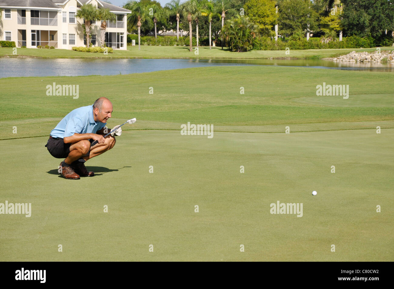 L'uomo allineando un colpo di golf su un campo da golf in Naples, Florida Foto Stock