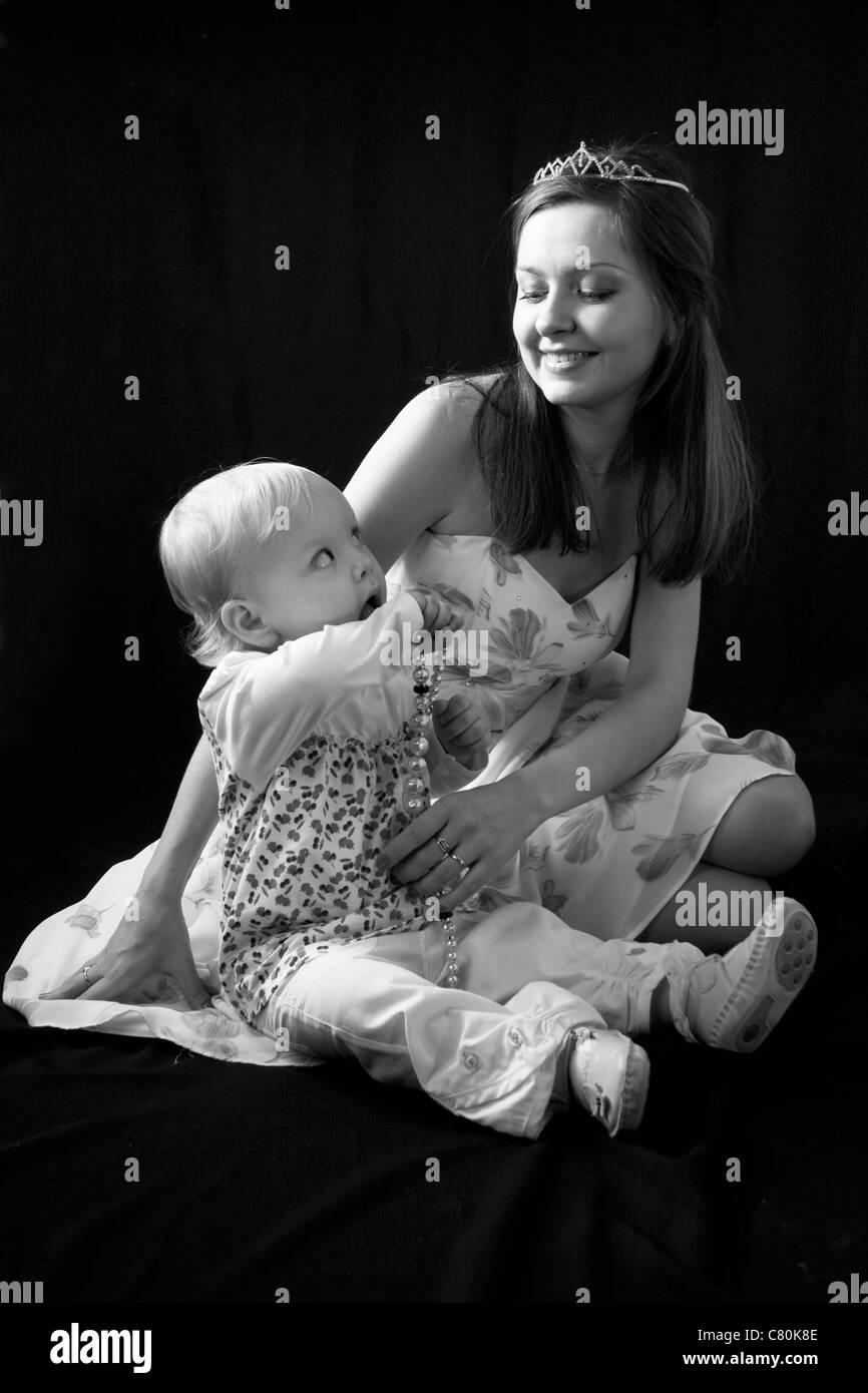 Il bambino e la madre felice isolato su nero Foto Stock