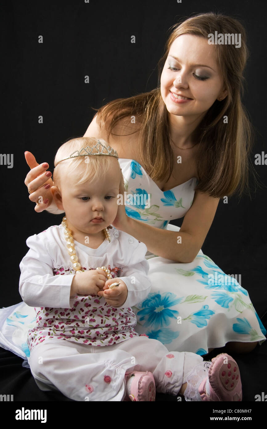 Baby Princess e madre felice isolato su nero Foto Stock