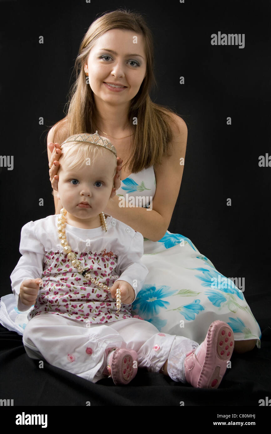 Baby Princess e madre felice isolato su nero Foto Stock