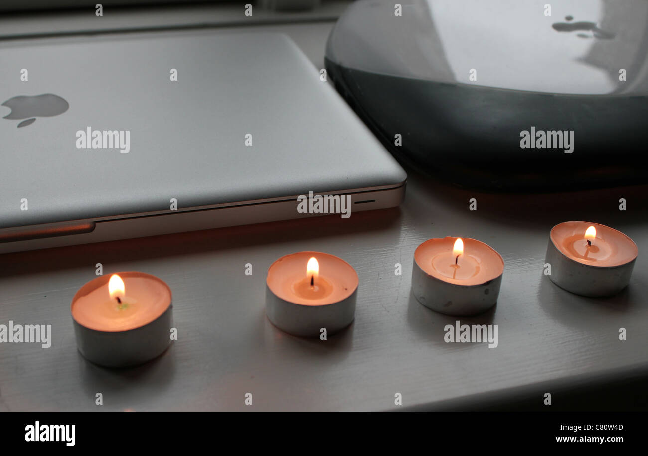 Computer Apple con candele dopo la morte di Steve Jobs - fianco a fianco con un nuovo MacBook Pro con un vecchio iBook laptop Foto Stock