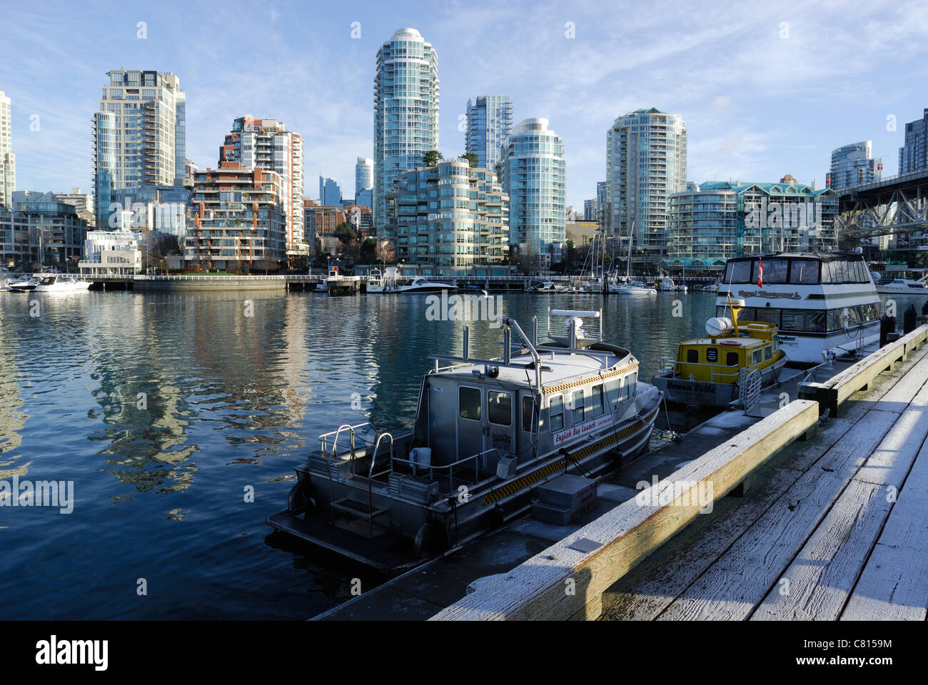 Smerigliati docks di Granville Island guardando verso nord-ovest attraverso False Creek porto verso Yaletown, città di Vancouver. Foto Stock