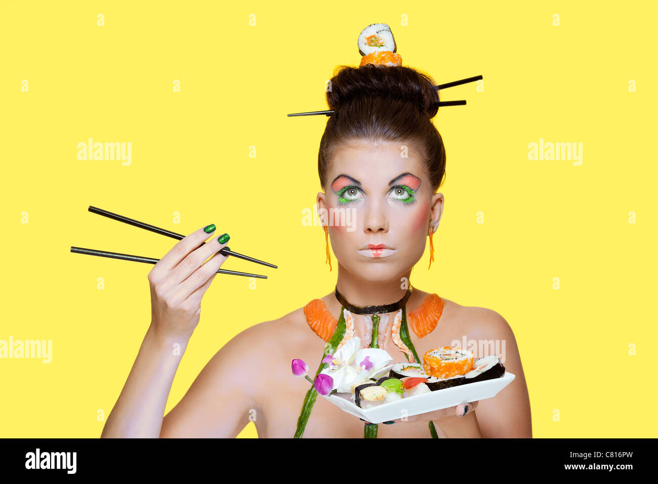 Un creative e di immagine colorata di un modello di moda indossando a tema asiatico trucco e materie sushi Foto Stock