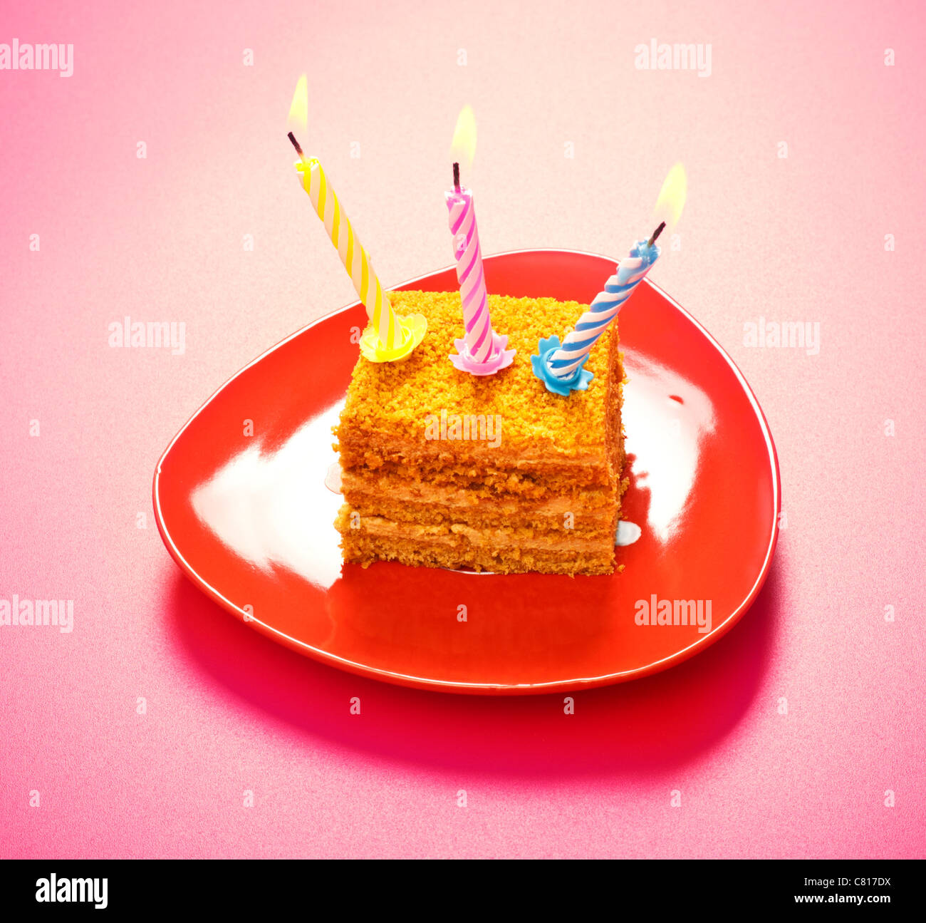 Torta di compleanno con candela su sfondo rosa Foto Stock