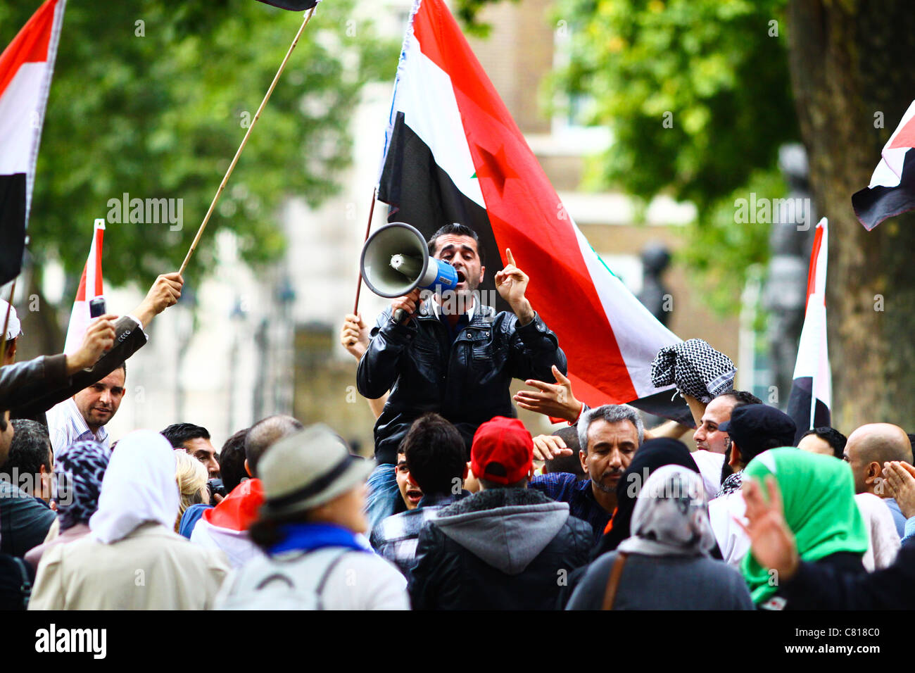 Un manifestante siriano conduce gli altri in canti contro il presidente siriano Bashar al-Assad a Downing Street a Londra, 2011. Foto Stock