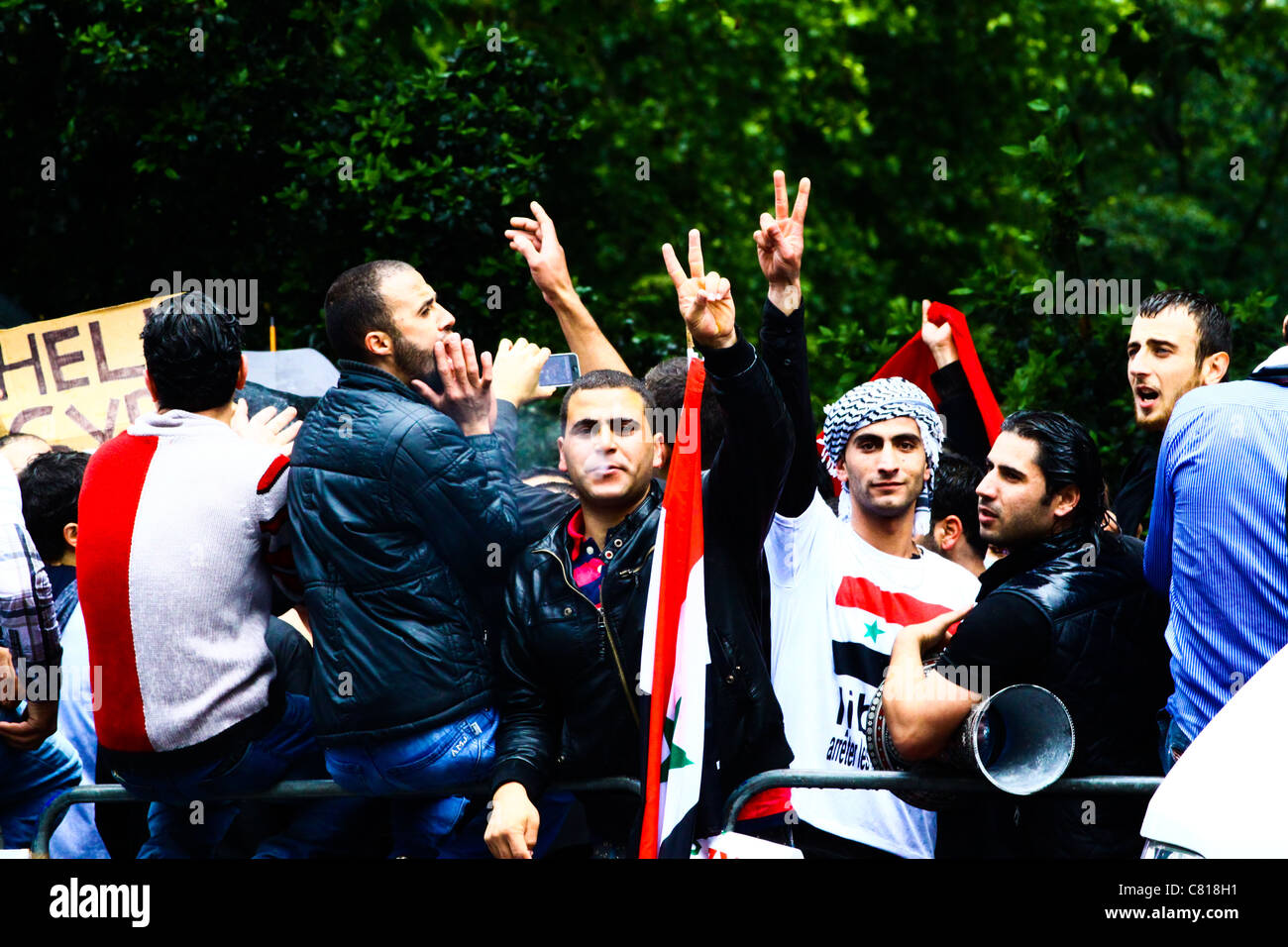 Cittadini siriani fare segni di pace a una protesta di fronte l'Ambasciata siriana a Londra, 2011. Foto Stock