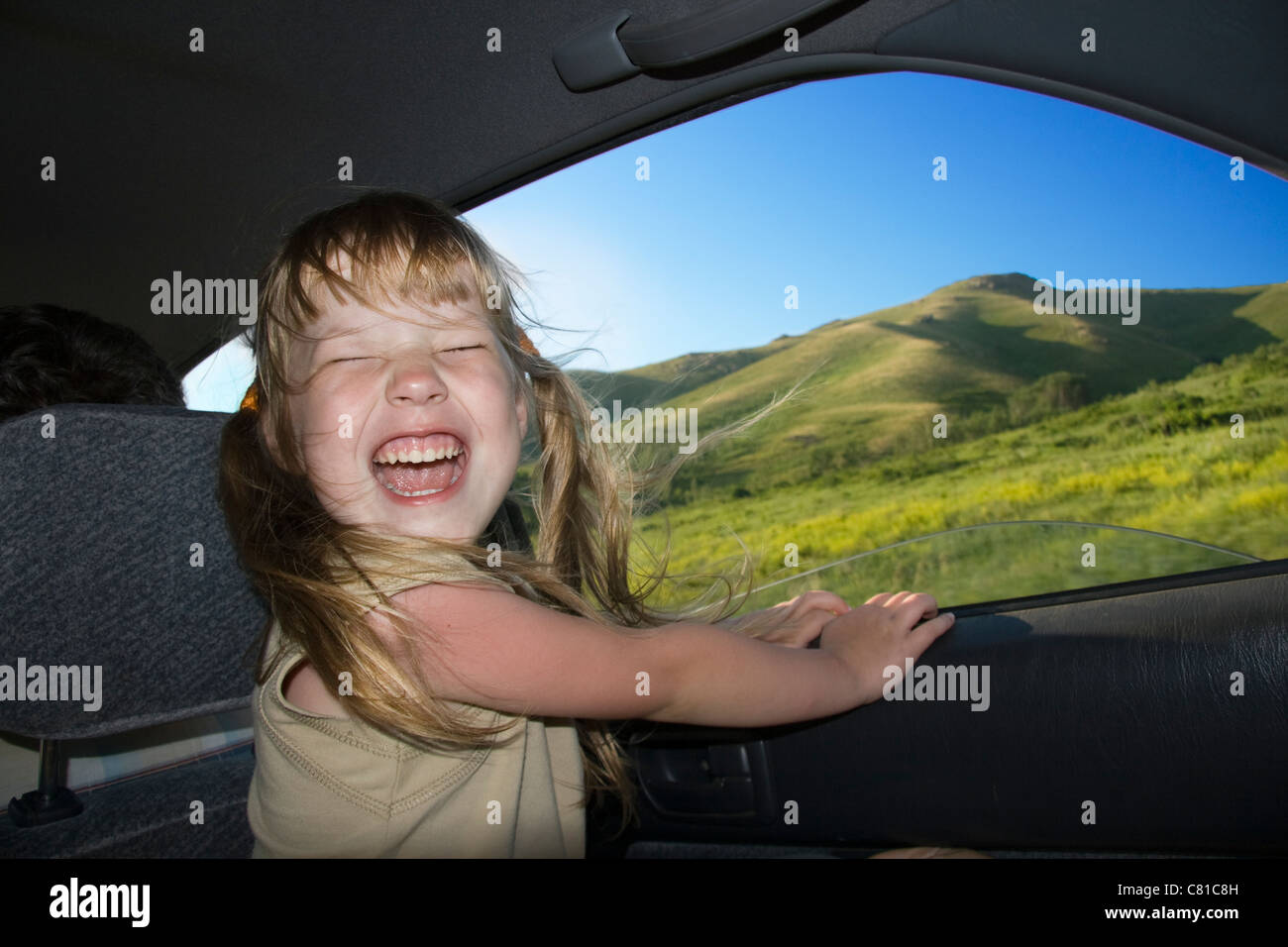 Poco divertimento ragazza velocità in auto vicino alla finestra aperta. Foto Stock