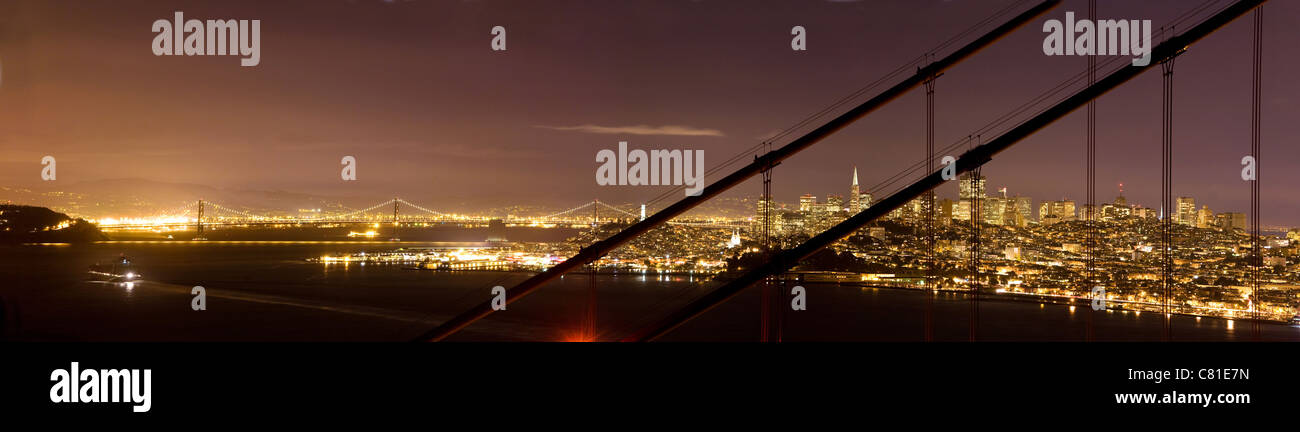 Il centro cittadino di San Francisco e il Bay Bridge, visto attraverso il Golden Gate Bridge Foto Stock