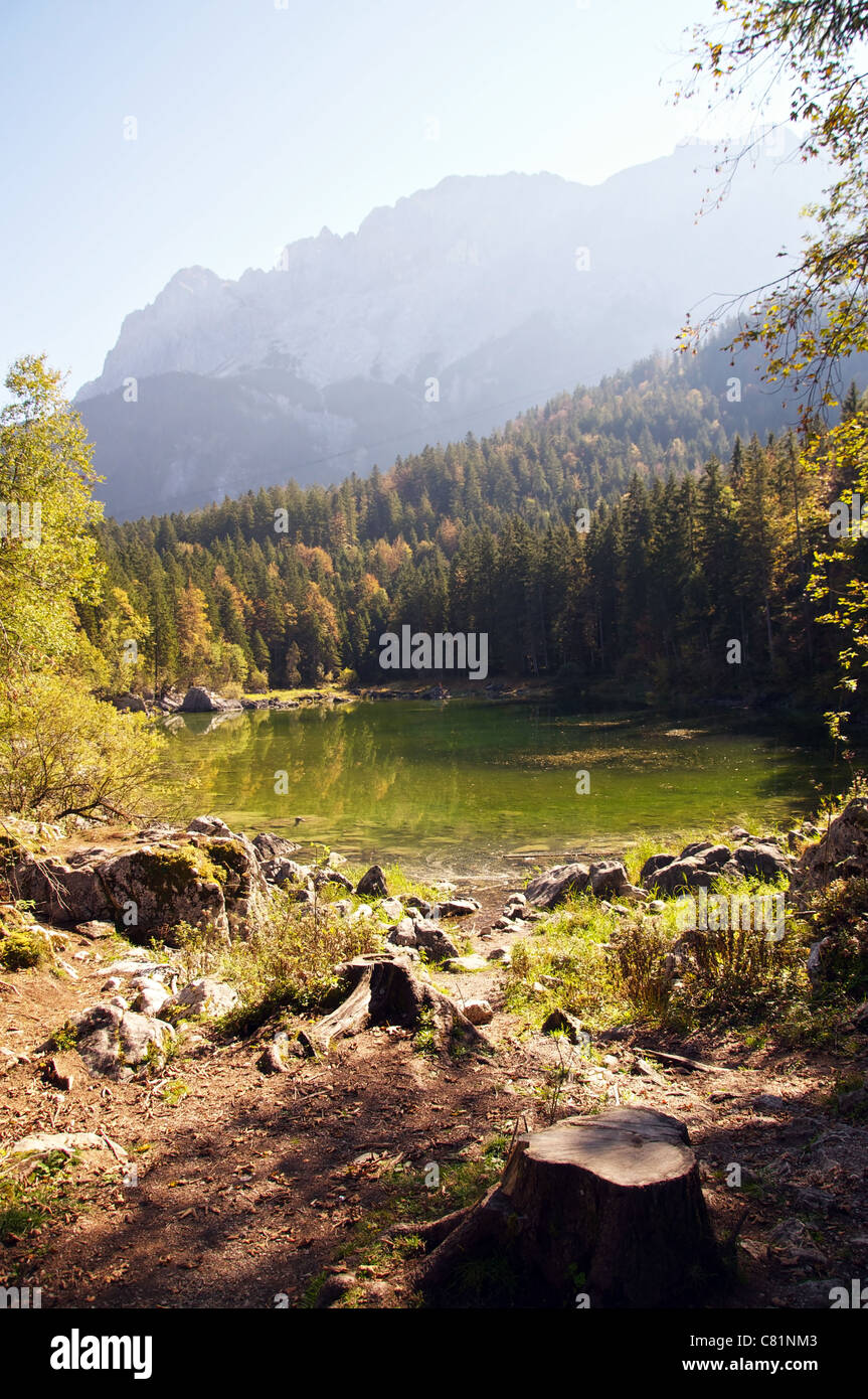 Sulla riva di un piccolo lago ai piedi delle Alpi Bavaresi in inizio di caduta Foto Stock