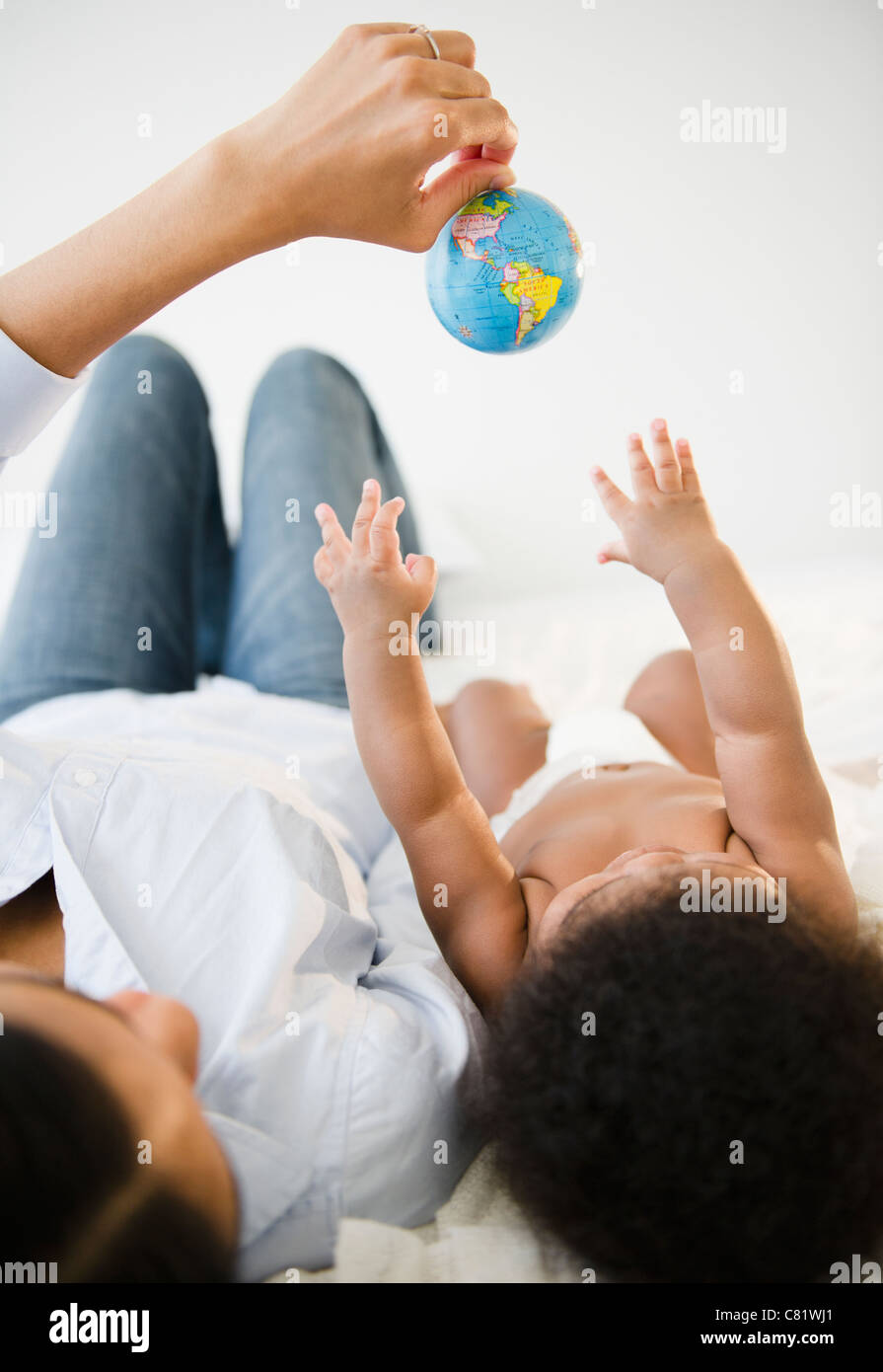 African American madre mostra globo per baby boy Foto Stock