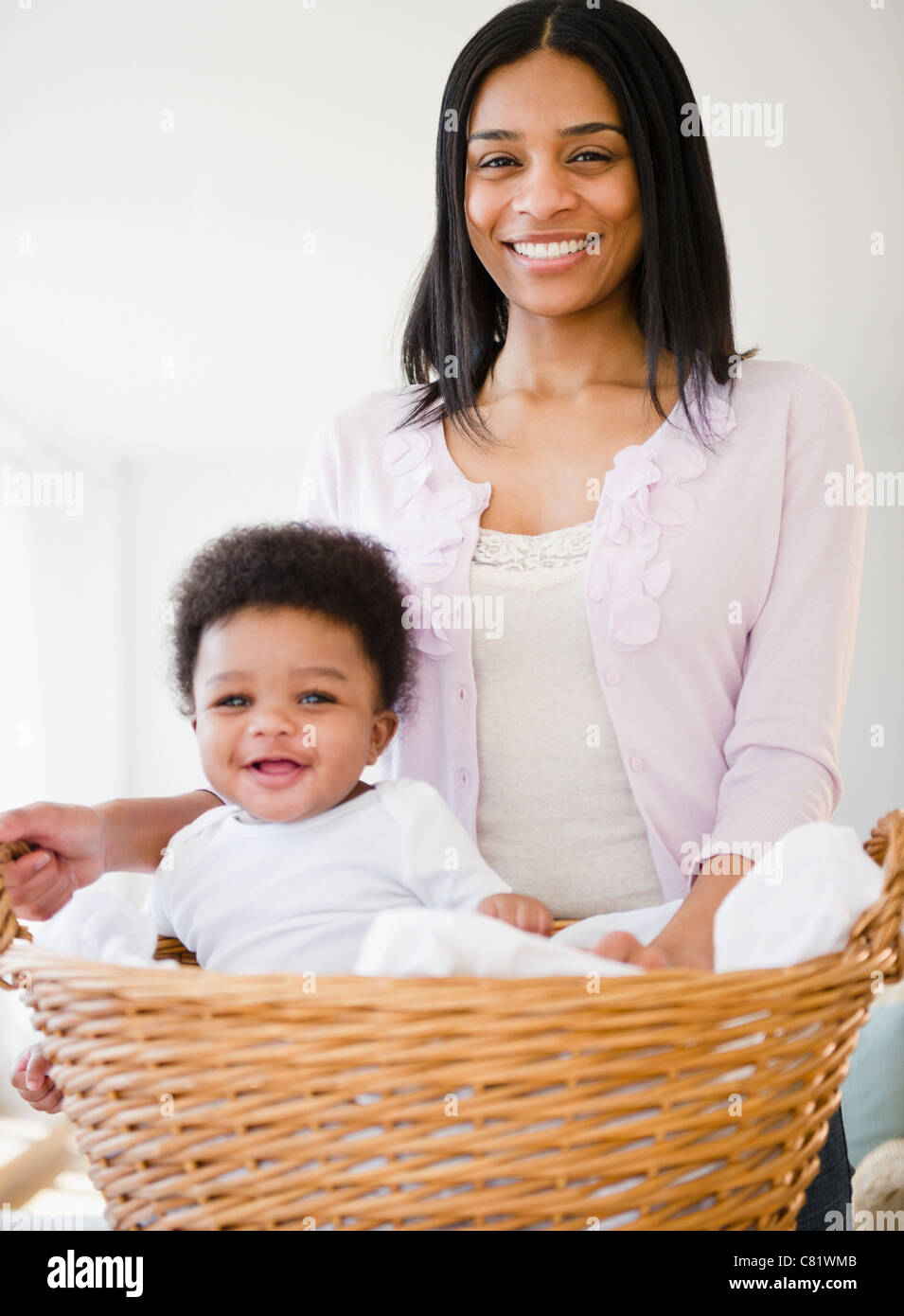 African American madre che trasportano baby boy in basket Foto Stock