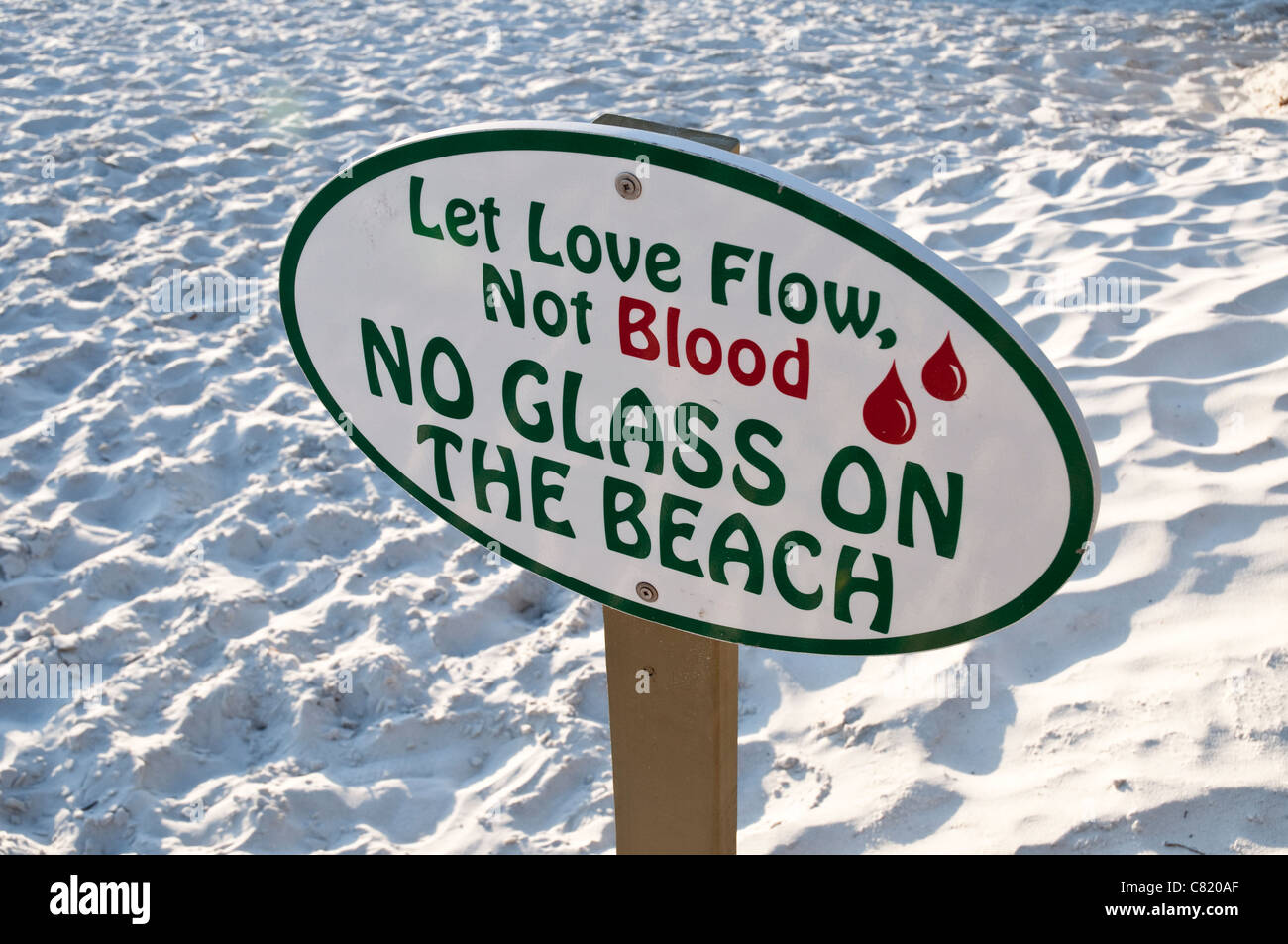 Un segnale di avvertimento su una spiaggia di sabbia bianca di rosmarino Beach, Florida, la lettura di "far amare il flusso, non il sangue, senza vetro sulla spiaggia". Foto Stock