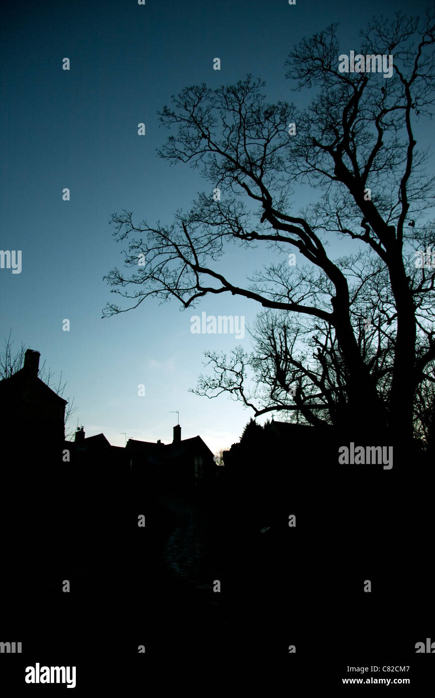 SIlhouette di un piccolo villaggio nel Cotswalds al crepuscolo Foto Stock