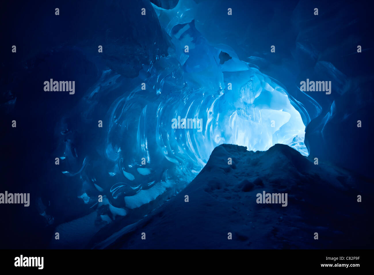 Blu grotta del ghiaccio coperto di neve e inondato di luce Foto Stock
