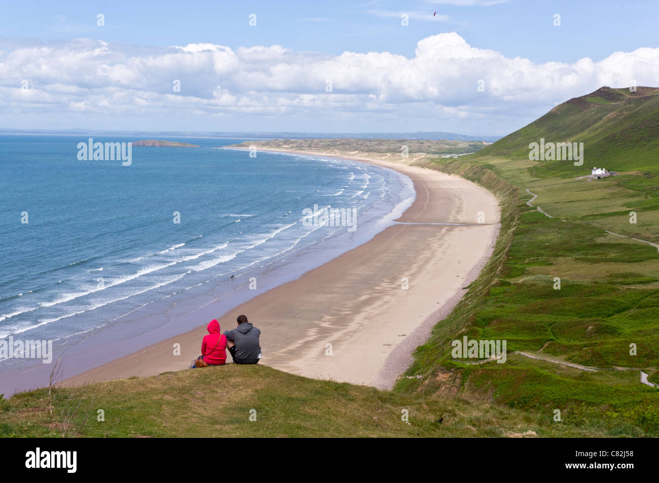Due persone lo sguardo su Rhossilli bay sulla Penisola di Gower Foto Stock