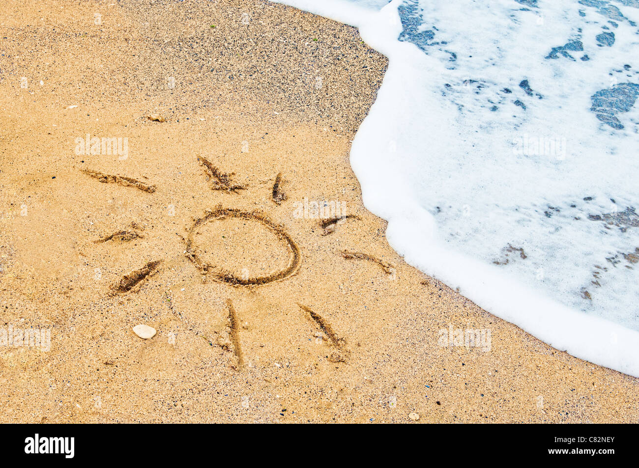 Disegno di sun nella sabbia sulla spiaggia esotica Foto Stock