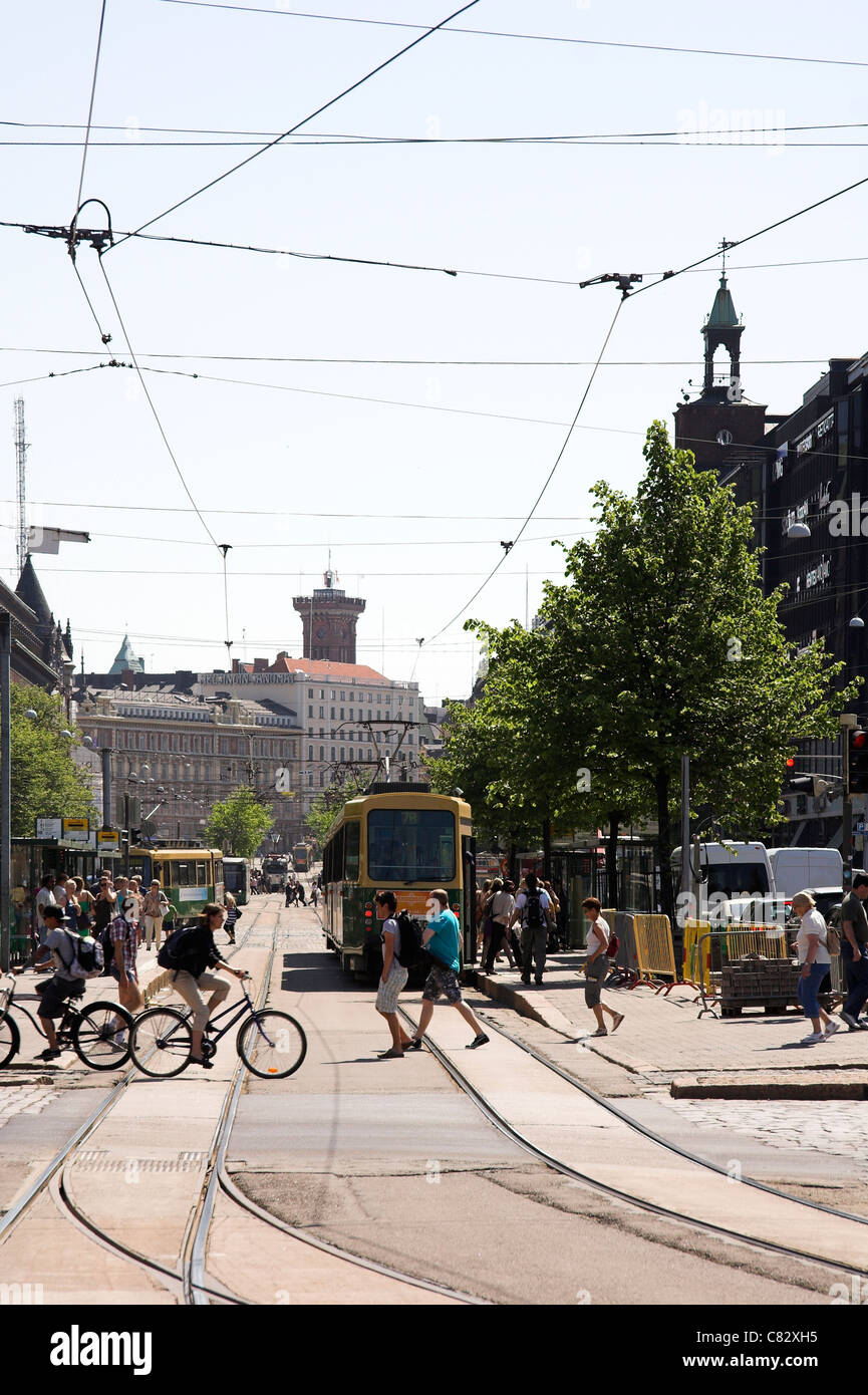 Strada trafficata scena con una fermata del tram e pedoni, Helsinki, Finlandia Foto Stock